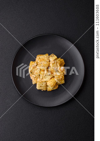 Delicious soft white feta cheese with salt, spices and herbs on a dark concrete background 111603688