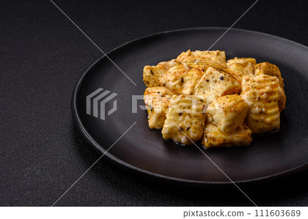 Delicious soft white feta cheese with salt, spices and herbs on a dark concrete background 111603689