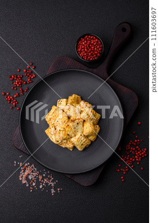 Delicious soft white feta cheese with salt, spices and herbs on a dark concrete background Delicious soft white feta cheese with salt, spices and herbs on a dark concrete background 111603697