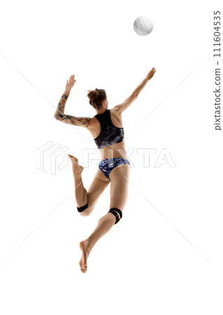 Rear view of young woman, beach volleyball player hits ball in motion against white studio background. Movement. Rear view of young woman, beach volleyball player hits ball in motion against white studio background. Movement. 111604535
