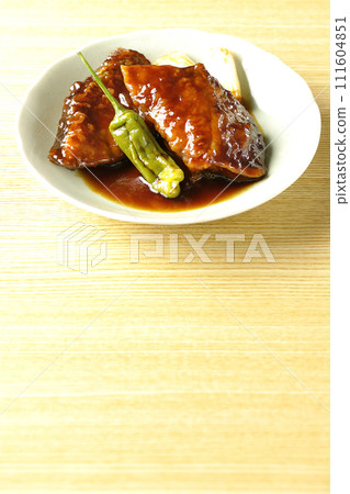 Teriyaki yellowtail with fried shishito and green onion 111604851