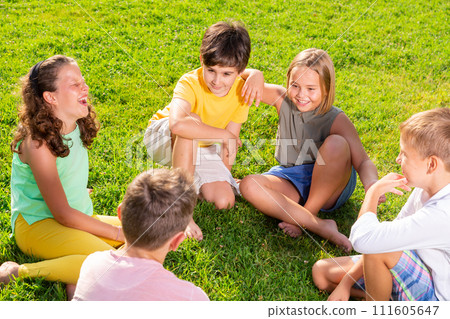 Group of kids sitting on grass Group of kids sitting on grass 111605647