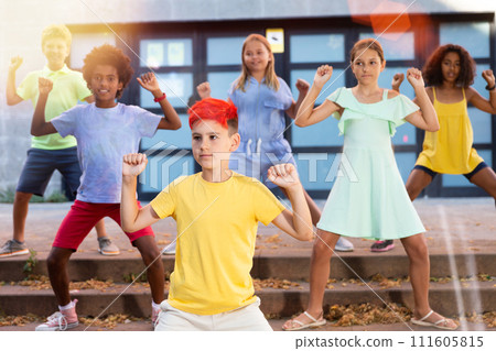 Tween boy dancing with friends on summer city street Tween boy dancing with friends on summer city street 111605815