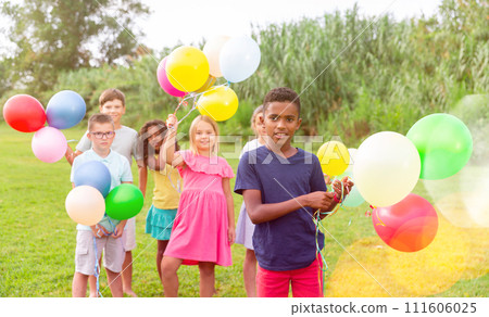 Barefoot kids playing with balloons on grass 111606025