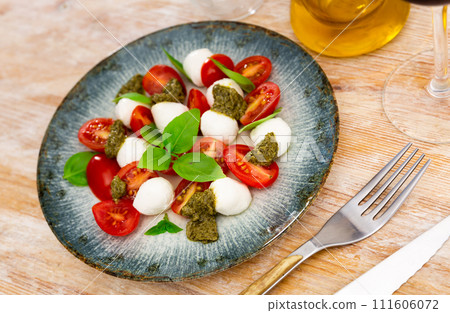Caprese salad with tomatoes, mozzarella, basil, pesto Caprese salad with tomatoes, mozzarella, basil, pesto 111606072