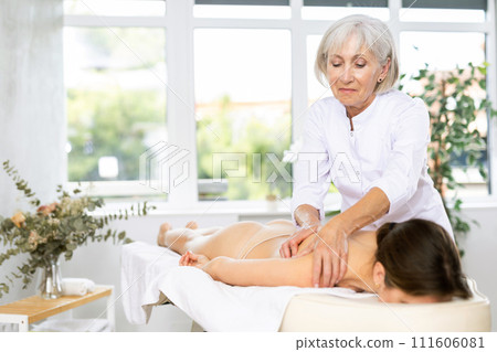 Unrecognizable young woman lies face down and enjoy shoulder massage for body care Unrecognizable young woman lies face down and enjoy shoulder massage for body care 111606081