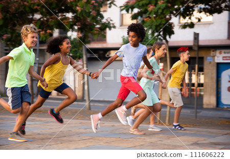 Happy children running together hand in hand through streets Happy children running together hand in hand through streets 111606222