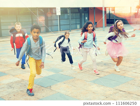 Team of positive schoolchildren running in race in the street 111606250