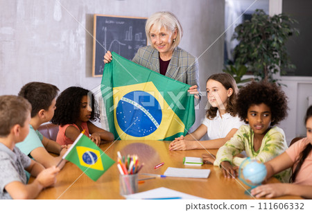Female teacher showing brazilian flag to kids in geography class Female teacher showing brazilian flag to kids in geography class 111606332