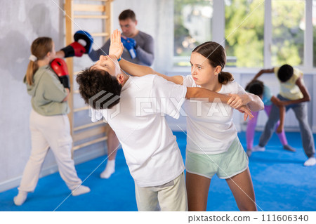 Preteen children pairs learning strength self-defense in gym 111606340