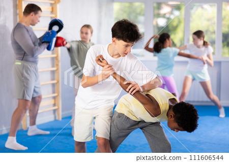 Teenager practicing painful armlock in sparring during self defence training 111606544
