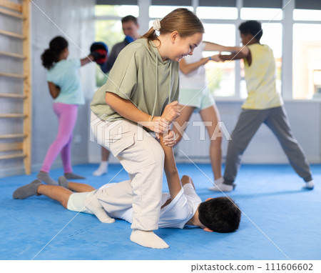 Self-defense - girl twists the arm of an attacking boy during self defense training 111606602