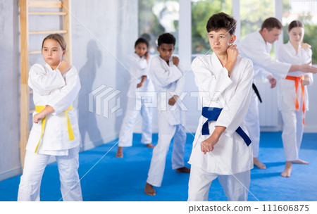 Group of children train karate techniques 111606875