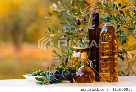Fragrant olive oil on the table with olive branches and fresh olives Fragrant olive oil on the table with olive branches and fresh olives 111606933