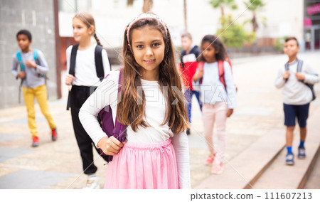 Smiling tween schoolgirl going to school on autumn day 111607213