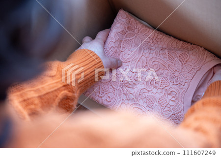 一位資深女性整理衣服的手 111607249