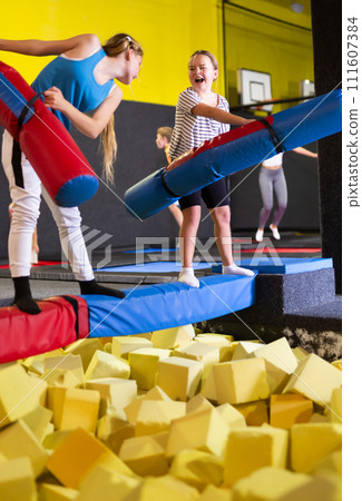 Preteen girl having fun on battle beam with female friend Preteen girl having fun on battle beam with female friend 111607384