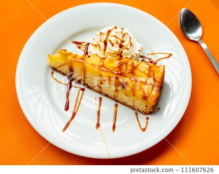Piece of apple pie with ice cream and caramel served on table 111607626