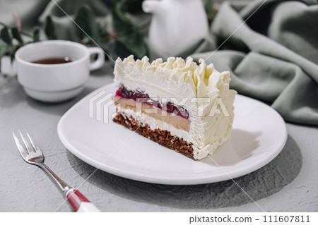 Layered Mousse Cake on white plate and cup of tea 111607811