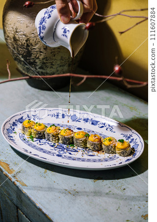 warm sushi maki rolls with cheese sauce sprinkled with soy sauce 111607884