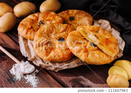 Cooking traditional pies with potatoes on wooden table 111607963
