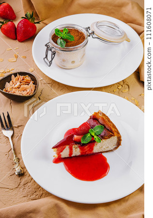 cheesecake with strawberry jam and tiramisu in a glass jar 111608071