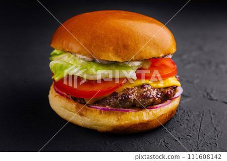 Appetizing cheeseburger on black stone closeup 111608142