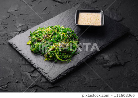 wakame chuka salad with spicy sauce on stone board 111608366