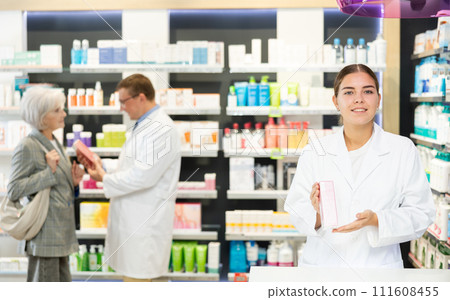Young female pharmacist demonstrating preparation in box Young female pharmacist demonstrating preparation in box 111608455