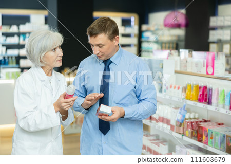 Modern pharmacy - female pharmacist advising man when purchasing intimate hygiene items 111608679