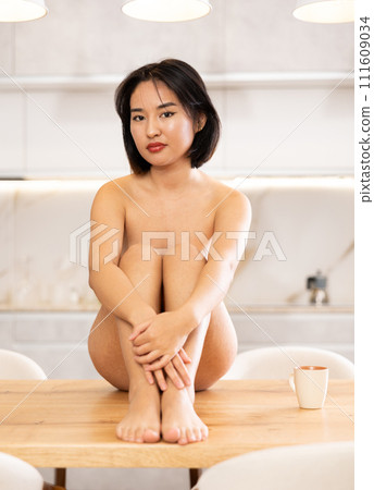 Young naked asian girl sitting on table Young naked asian girl sitting on table 111609034