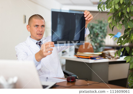 Male doctor examining x-ray at clinic 111609061
