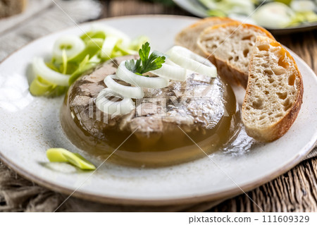 Homemade pork aspic, meat jelly with onion and leek in a white plate Homemade pork aspic, meat jelly with onion and leek in a white plate 111609329