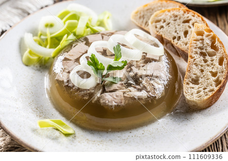 Homemade pork aspic, meat jelly with onion and leek in a white plate Homemade pork aspic, meat jelly with onion and leek in a white plate 111609336