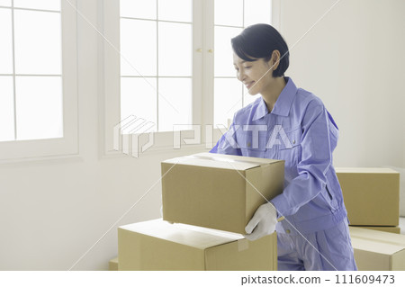 Female staff of a moving company carrying cardboard 111609473