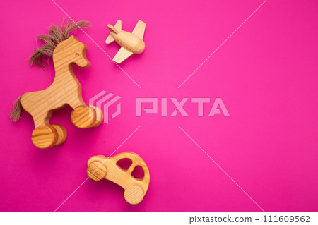 Wooden horse on pink background. Eco-friendly. Greeting card. Flat lay Wooden horse on pink background. Eco-friendly. Greeting card. Flat lay 111609562