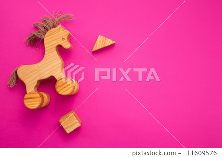 Wooden horse on pink background. Eco-friendly. Greeting card. Flat lay Wooden horse on pink background. Eco-friendly. Greeting card. Flat lay 111609576