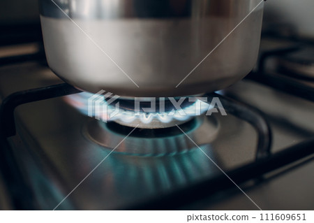 Burning gas fire flame on a kitchen gas stove a saucepan 111609651
