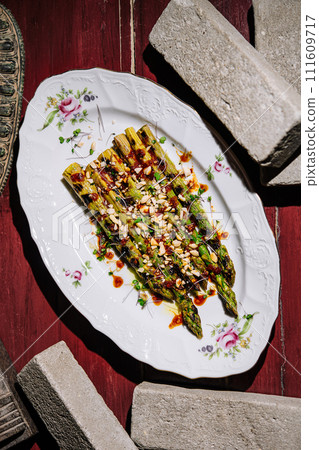 Baked asparagus with pine nuts on plate 111609717