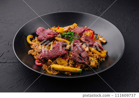 Chinese fried rice with beef on black plate Chinese fried rice with beef on black plate 111609737