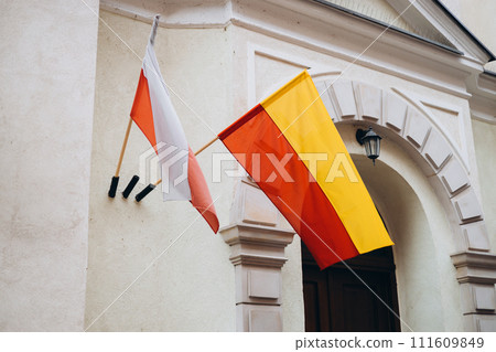 Warsaw flag and Flag of Poland on facade of a building waving in the wind. Celebrating Polish National Flag Day. Warsaw flag and Flag of Poland on facade of a building waving in the wind. Celebrating Polish National Flag Day. 111609849