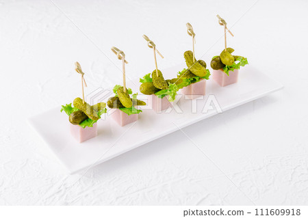 pieces of ham with small pickled cucumbers 111609918
