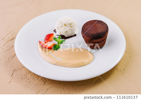 White plate with chocolate fondant cake White plate with chocolate fondant cake 111610137