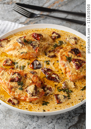 Marry Me Chicken is a dish of tender sauteed chicken in a rich and creamy sun-dried tomato sauce closeup on the plate. Vertical 111610308
