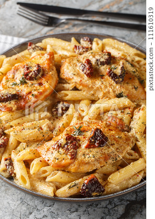 Marry me chicken pasta with sun-dried tomatoes and Parmesan in a creamy sauce closeup on the plate. Vertical Marry me chicken pasta with sun-dried tomatoes and Parmesan in a creamy sauce closeup on the plate. Vertical 111610319