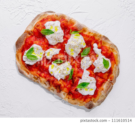 Italian pizza with mozzarella cheese and tomato topped with fresh basil 111610514