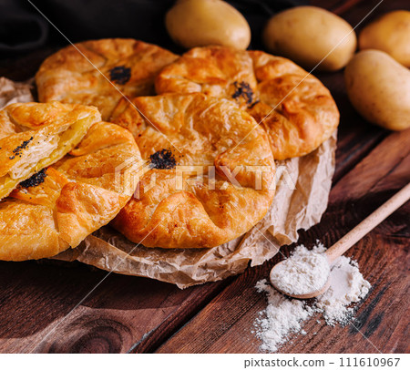 Cooking traditional pies with potatoes on wooden table 111610967