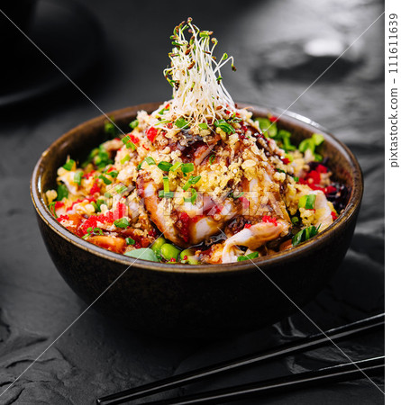 Salad with eel and couscous on black bowl 111611639