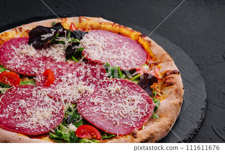 Delicious pizza with salami, arugula and tomatoes Delicious pizza with salami, arugula and tomatoes 111611676