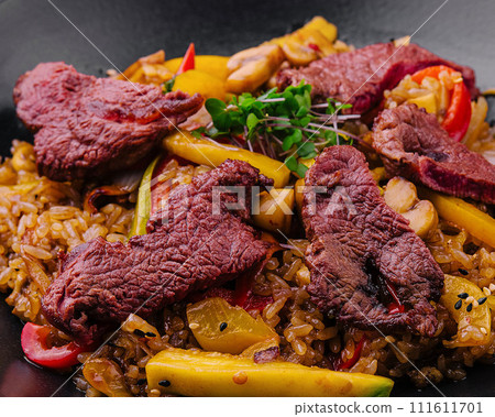 Chinese fried rice with beef on black plate Chinese fried rice with beef on black plate 111611701